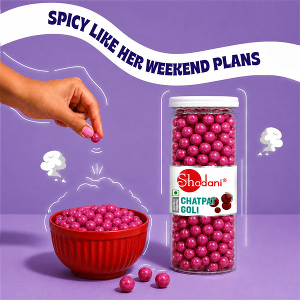 A hand sprinkles pink chatpata goli candy into a red bowl next to a clear plastic jar of Shedani Chatpata Goli candies on a purple background with a promotional banner.