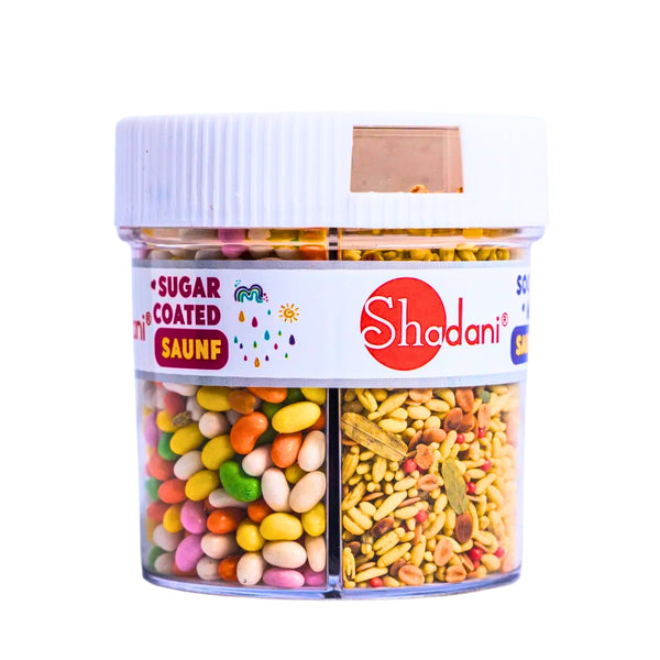 A clear plastic jar of Shadani 3 in 1 Saunf with visible compartments containing different flavored fennel seeds. The packaging is multicolored, with branding and product information displayed.