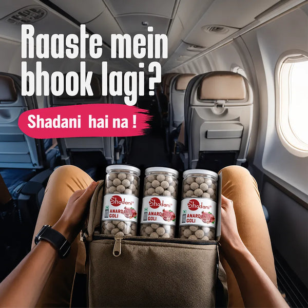 Person holding a bag of Shadani Anardana Goli in an airplane seat with text overlay.