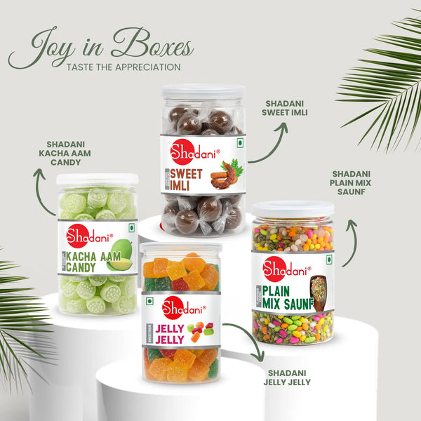 Assorted Shadani candy packages on a white surface with green leaves. Corporate gift hamper products 