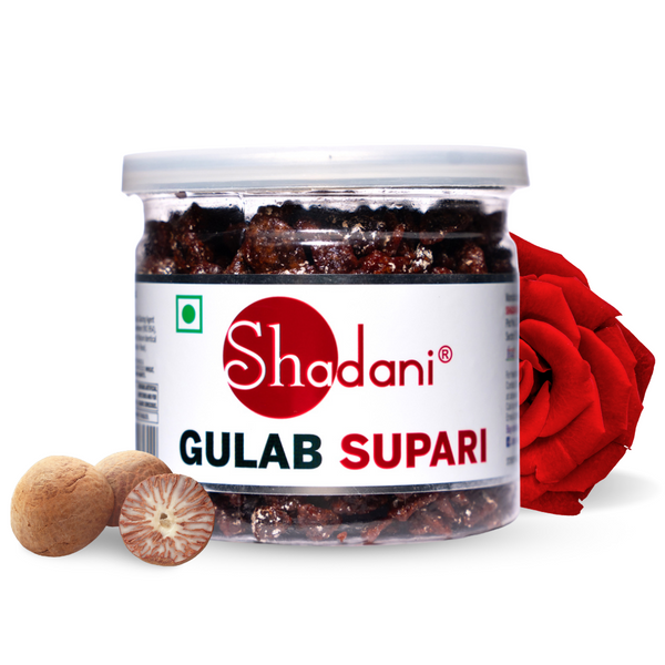 A clear plastic jar of Shadani Gulab Supari with a white label, red rose petals, and a nut visible in the foreground.