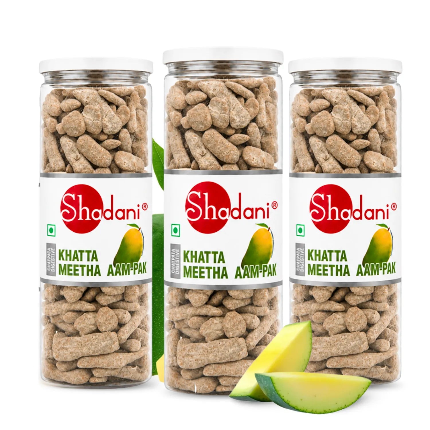 Three clear plastic jars of Shadani Khatta Meetha Aam-Pak with white lids, filled with light brown dried flower petals, arranged on a white background with two green mango slices in front.