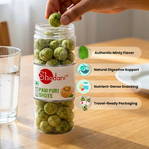 Shadani Pani Puri Shots in a glass jar on a wooden surface with a hand holding a shot.