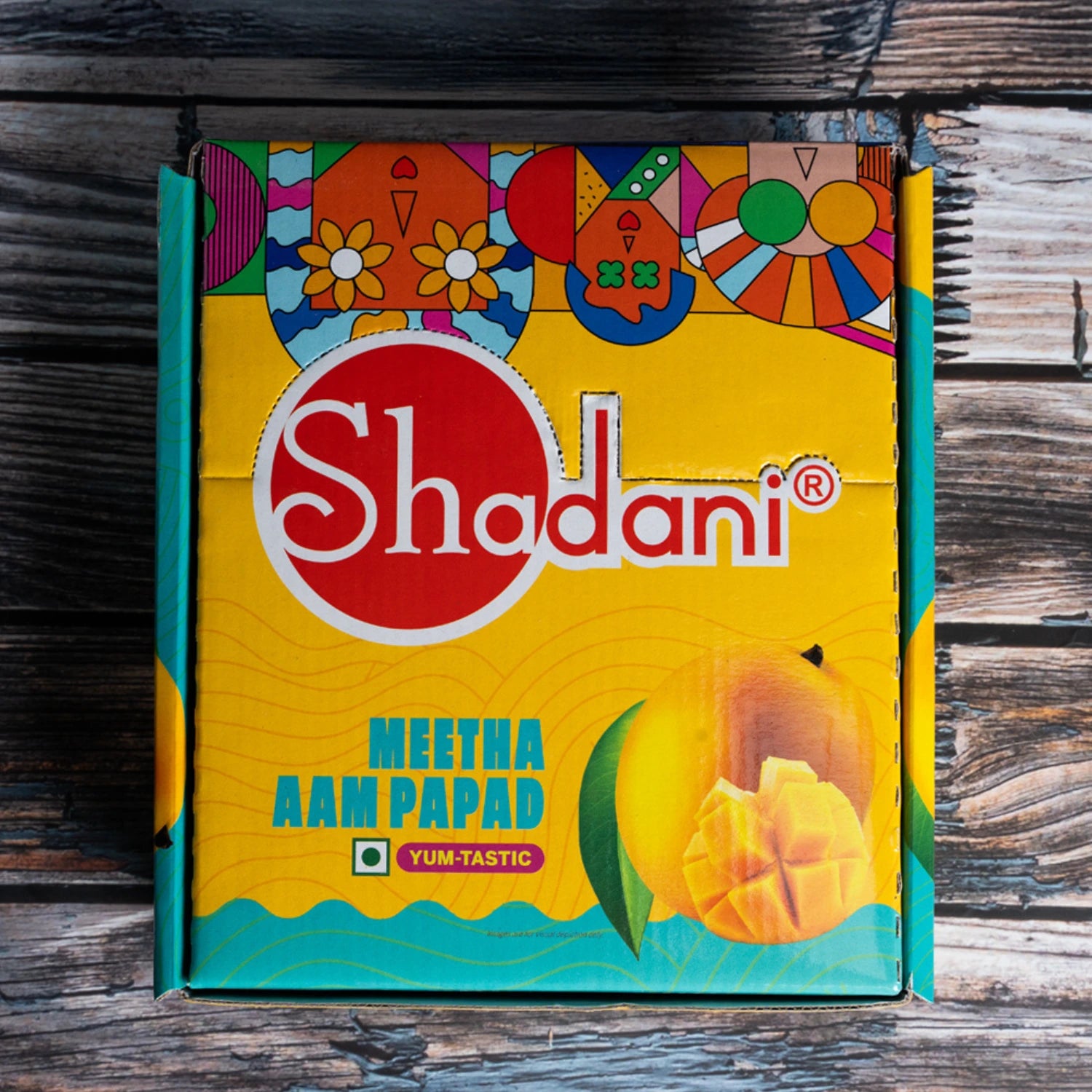 Shadani Meetha Aam Papad packaging on a wooden surface
