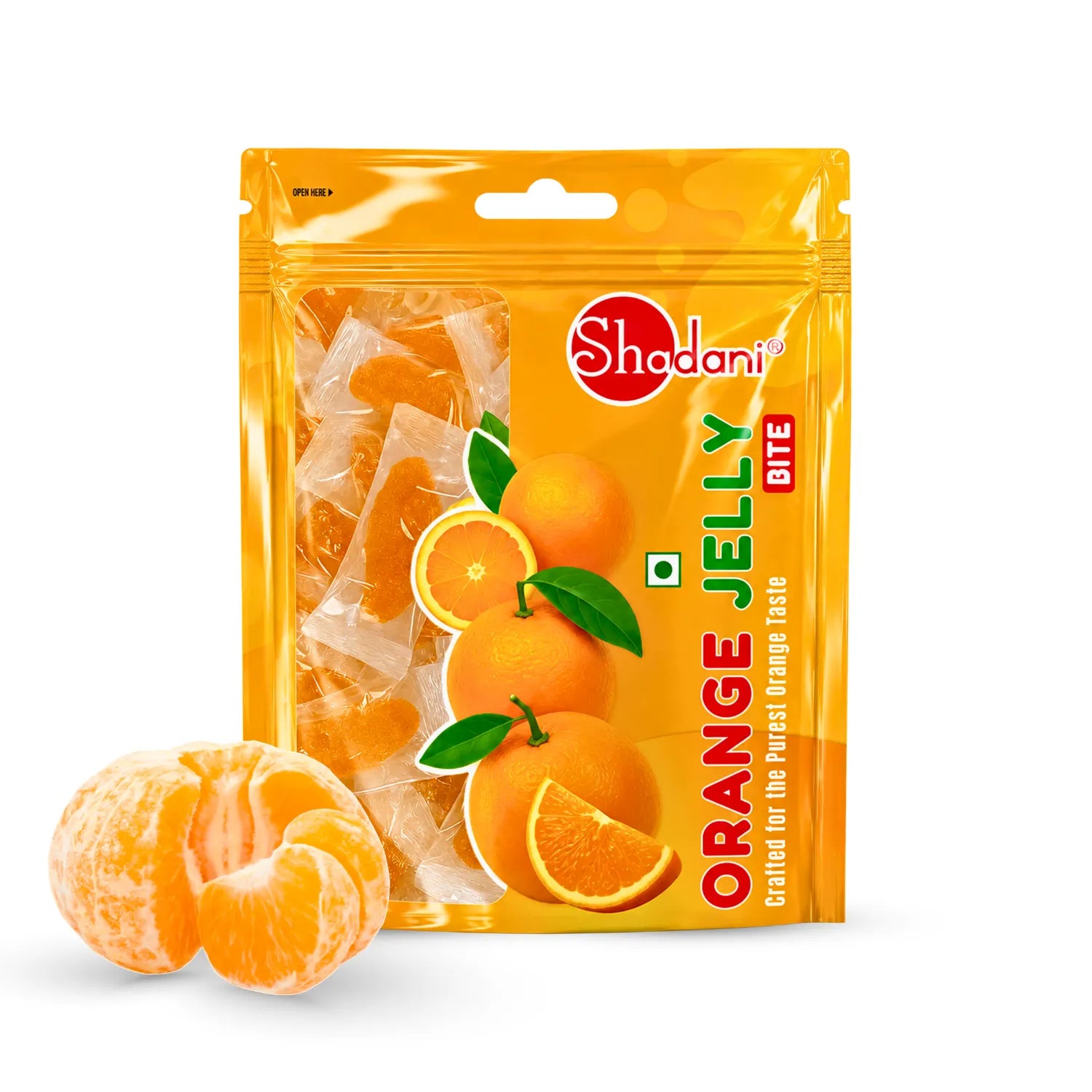 Shadani Orange Jelly Bite candy in a bright orange stand-up pouch, shown with two peeled orange candies and orange slices in front on a white background.