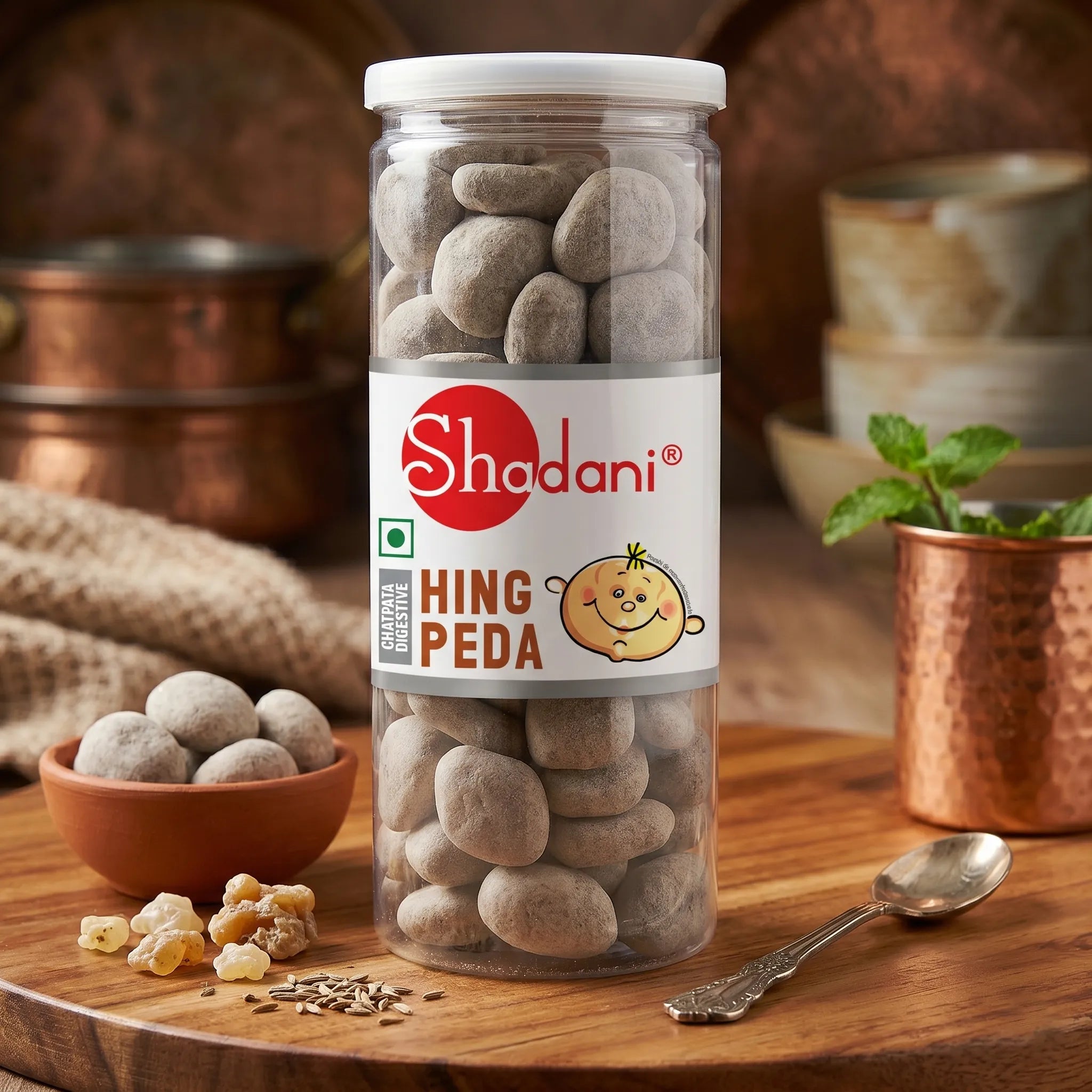 Can of Shadani Hing Peda on a wooden surface with a bowl and spoon.