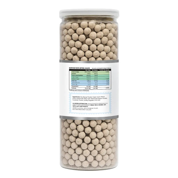 Tall cylindrical container filled with round beige jeera goli on a white background