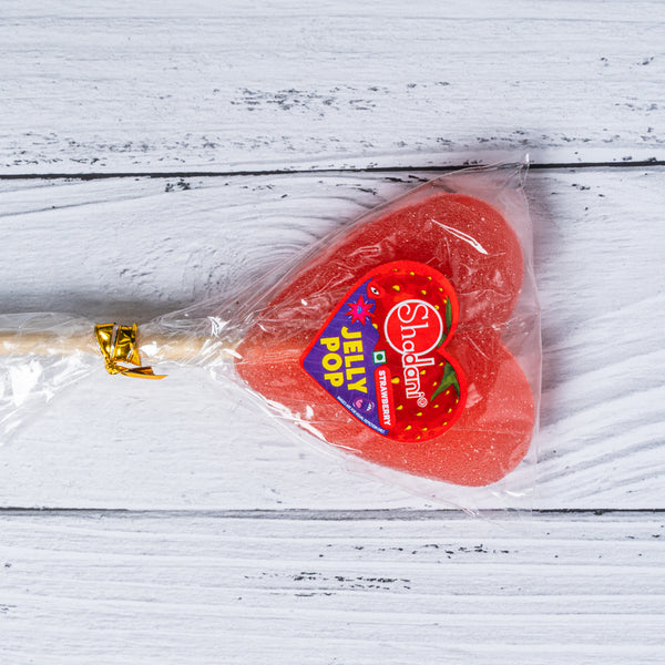 Sheldon Strawberry Jelly lollipop in clear packaging on a white wooden surface